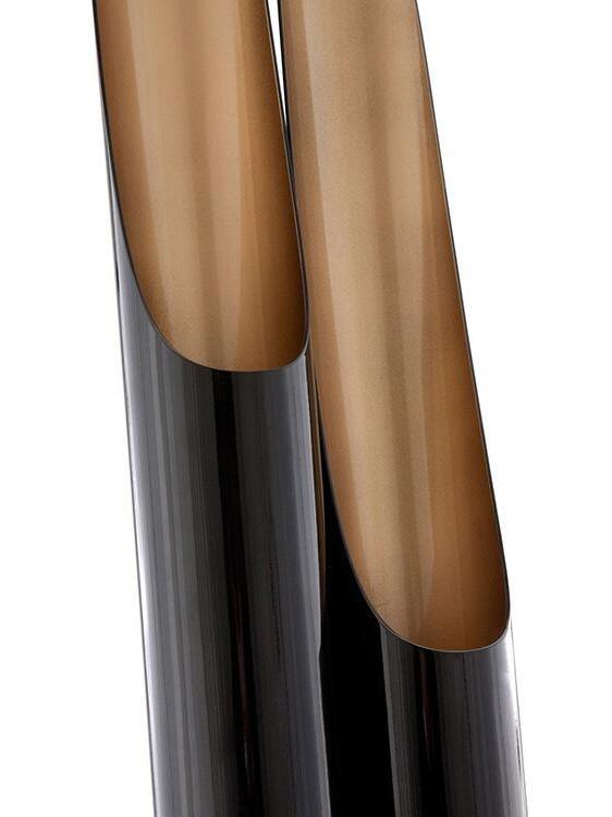 Close-up of two unlit black tubes with angled cutouts and bronze-coloured inner surfaces