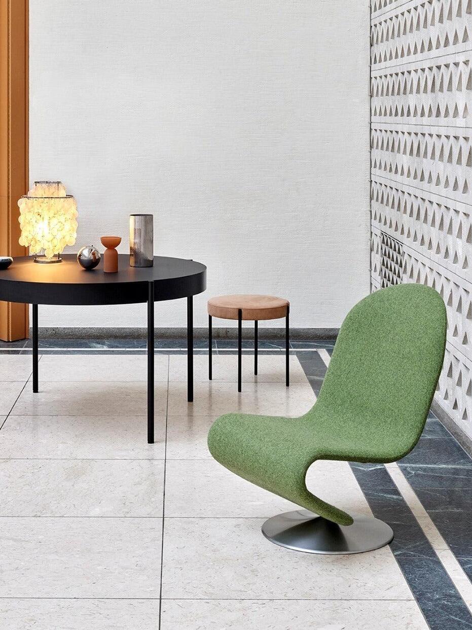 Shell table lamp on black table near green chair