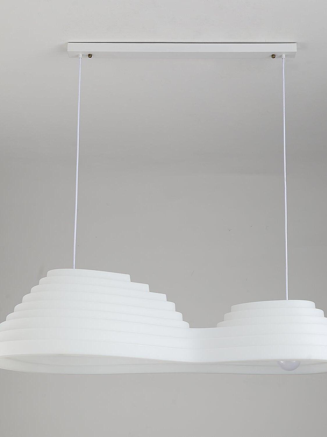 Unlit elongated stepped pendant suspended on two cords from a rectangular white ceiling canopy.
