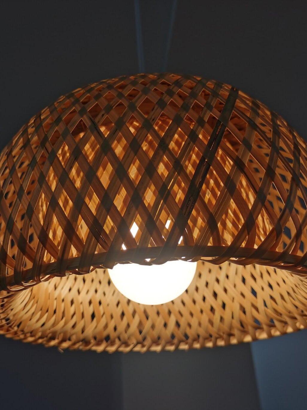 Close bulb glowing through diagonal bamboo lattice