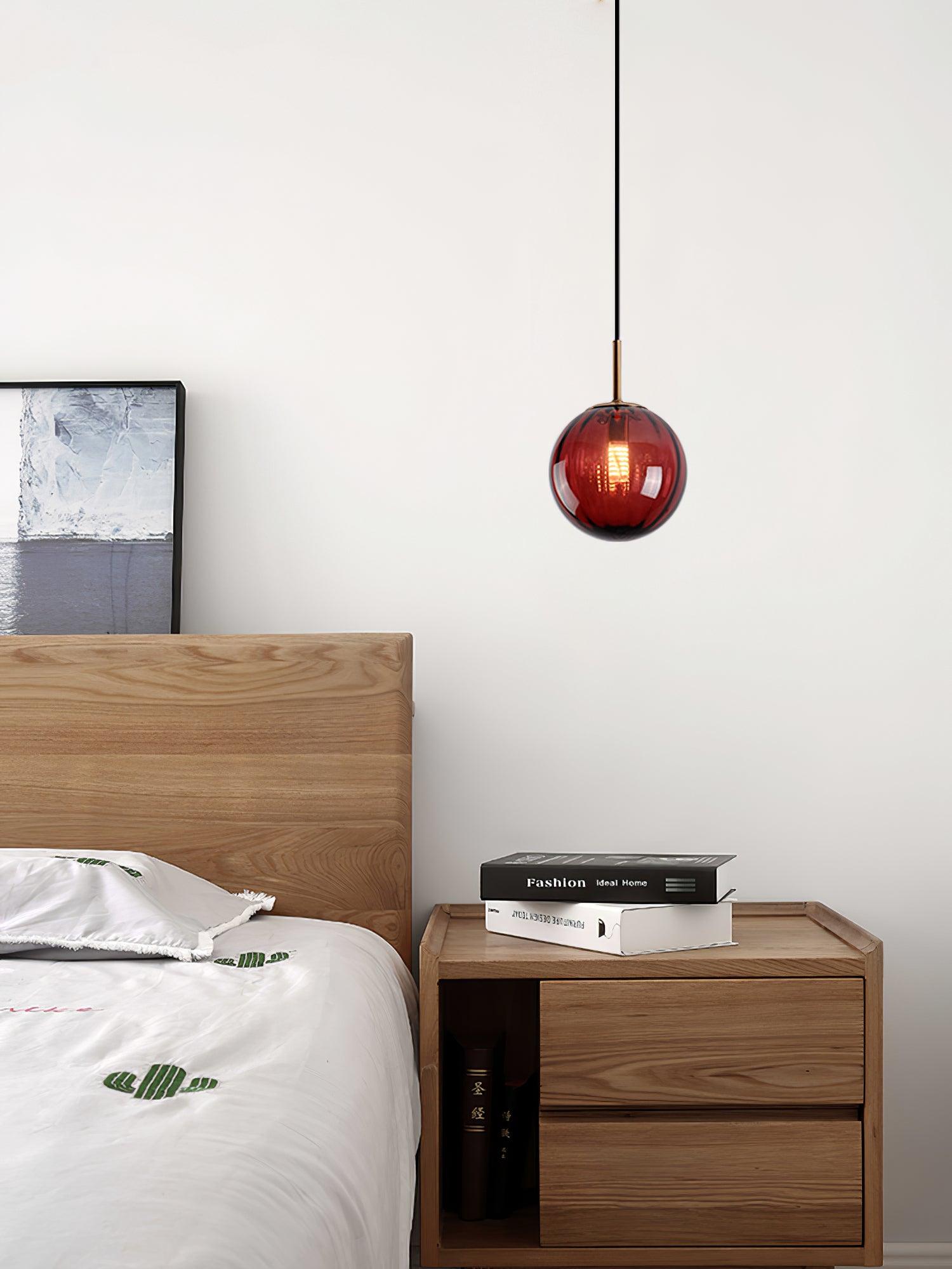 Wine red globe above a bedside cabinet