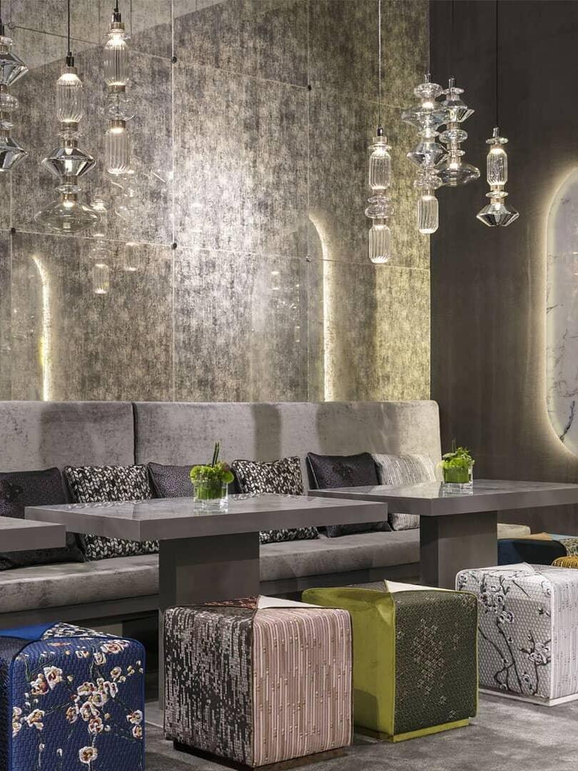 Multiple clear and smoky pendants along a dining table