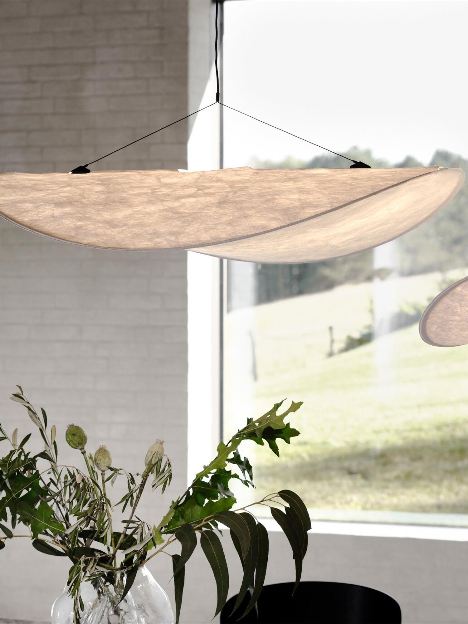 Curved textured shade above a dining area