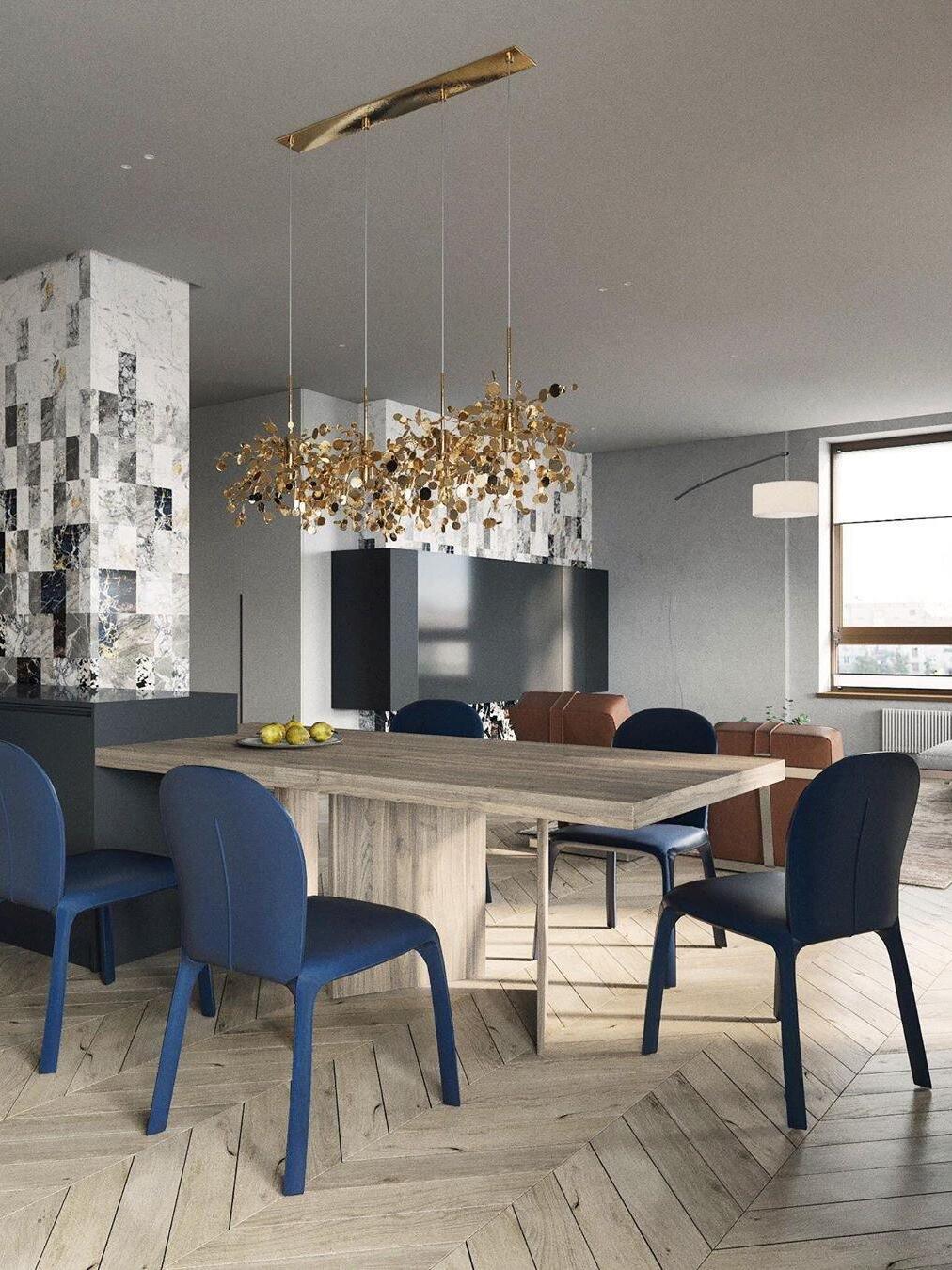 Gold disc chandelier over a light table in an open living space