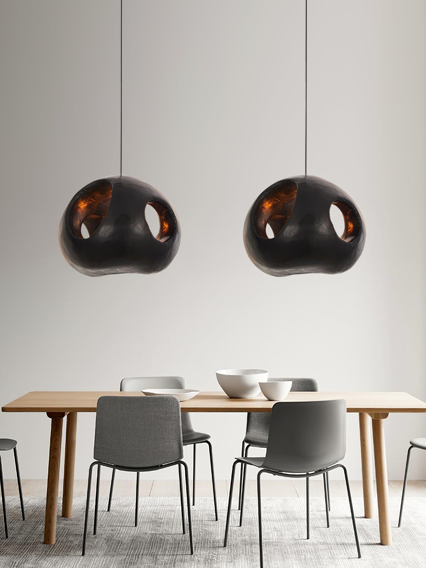 Pair of separately suspended black pendants above a table