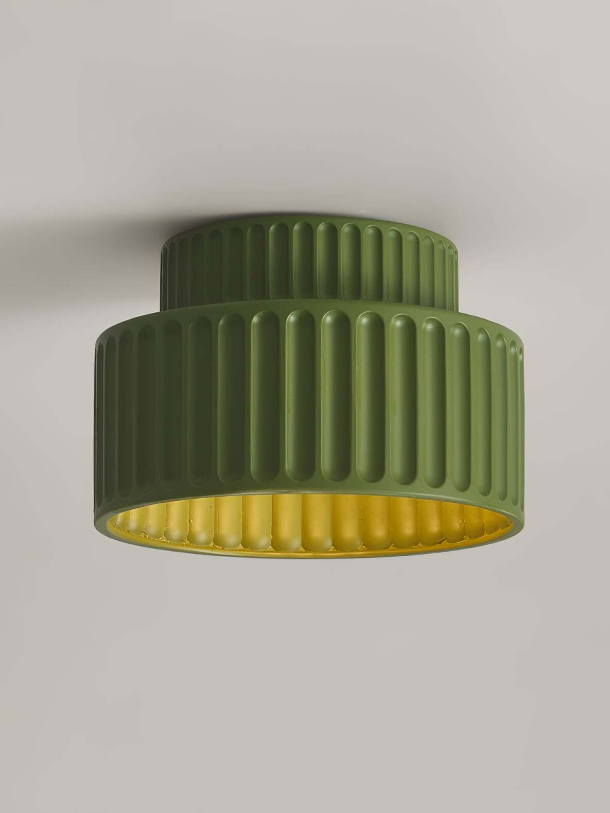 Green ribbed ceiling lamp with lit lower opening
