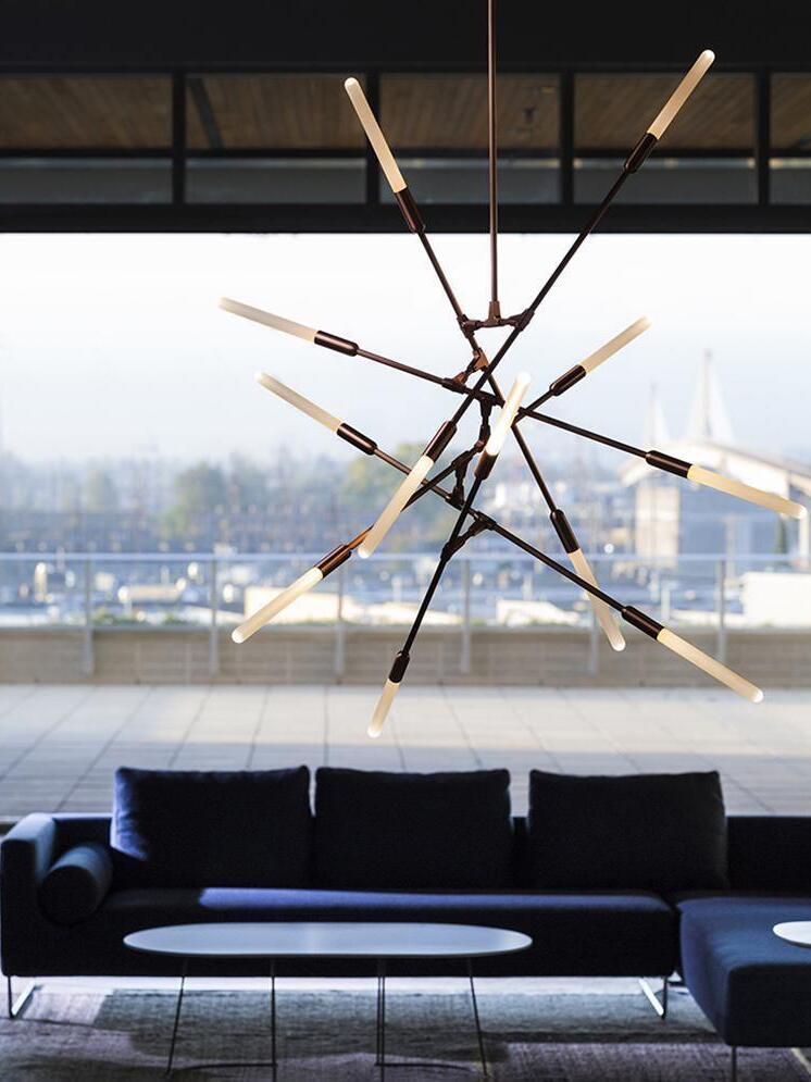 Dark vertical branch chandelier near a large window