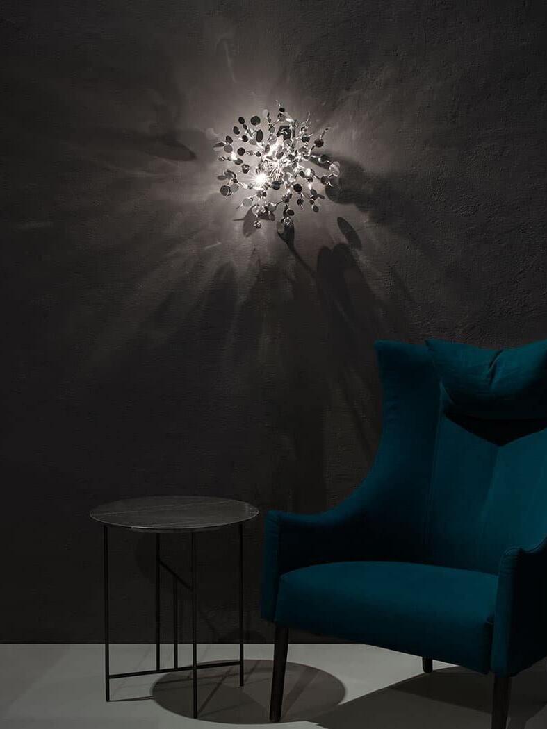 Lit silver disc cluster casting round shadows on a dark wall