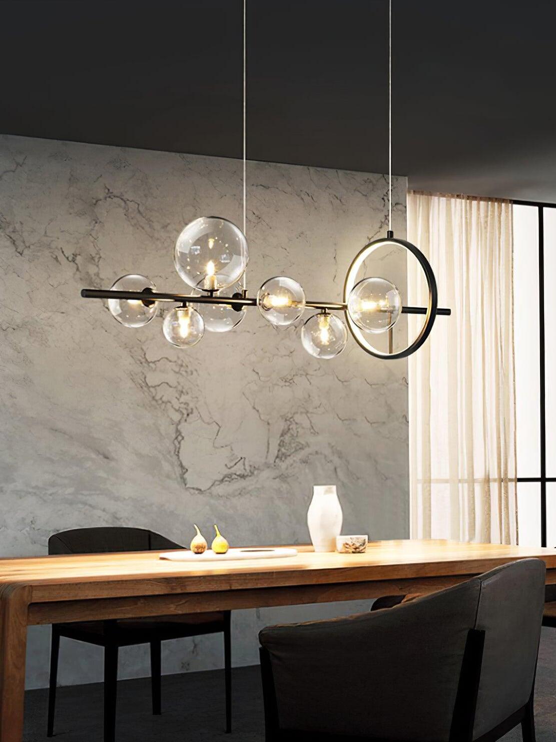 Glass globe and LED-ring chandelier above a long wooden table