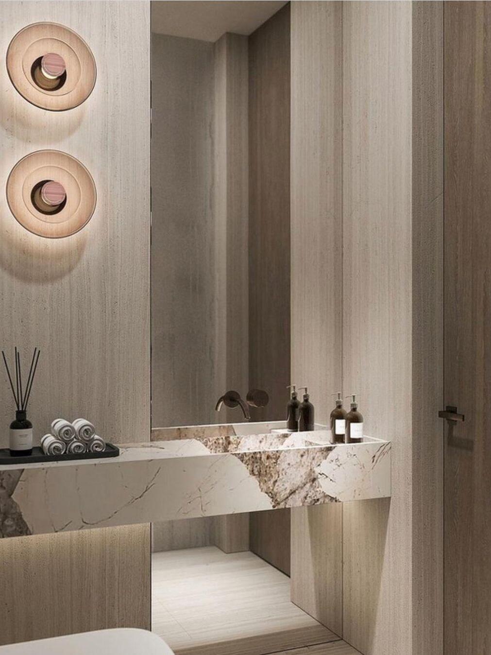 Two amber glass-disc wall lights beside vanity