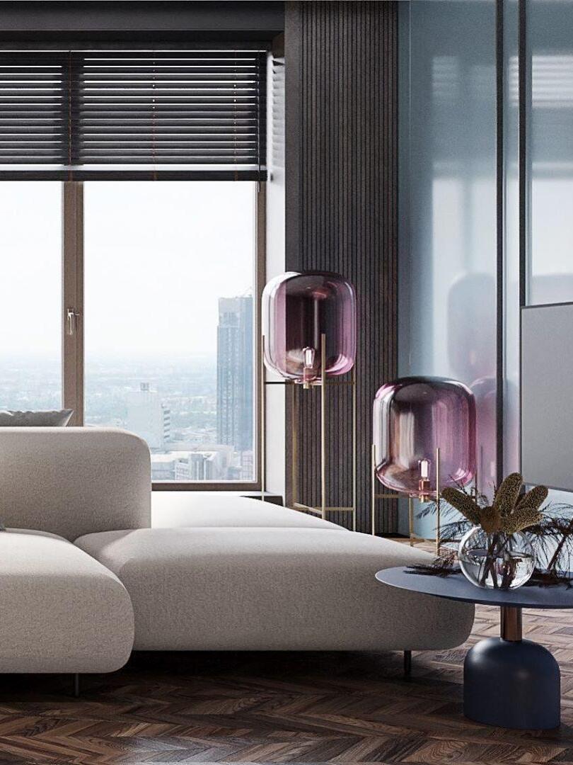 Two pink-tinted glass lamps on black stands beside a white sofa.