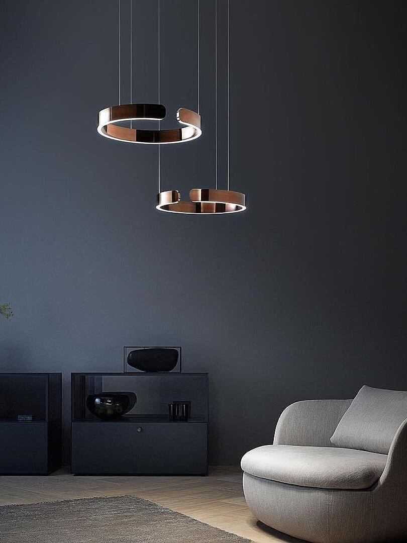 Two suspended metallic rings against a blue wall