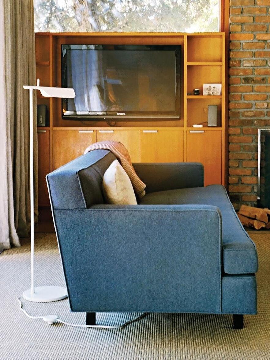 White floor lamp beside a living-room sofa