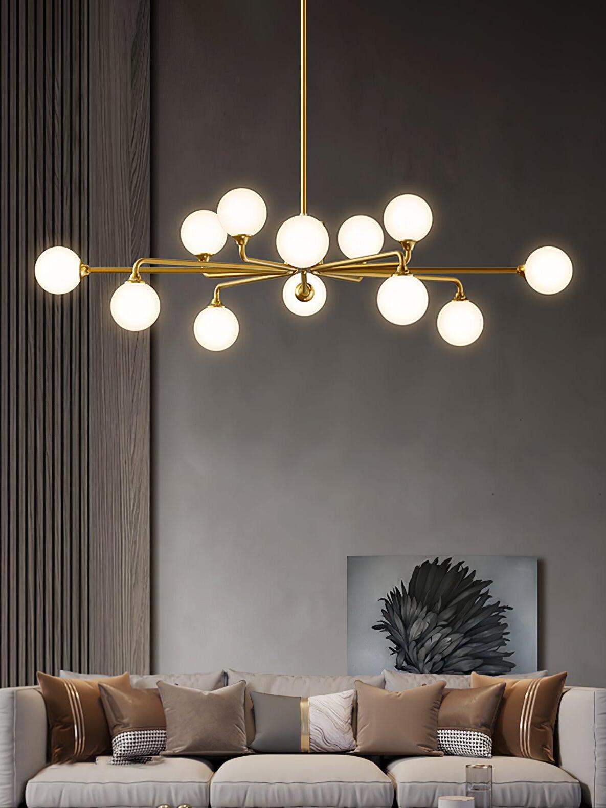 Brass and white globe chandelier over living-room couch