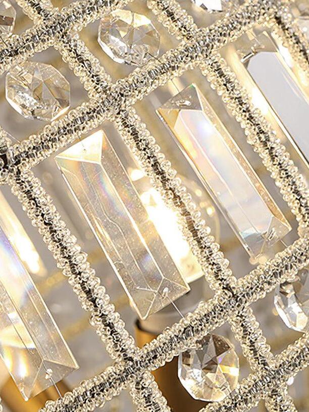 Diagonal close view of lit rectangular faceted crystals, smaller round pieces and beaded cage ribs