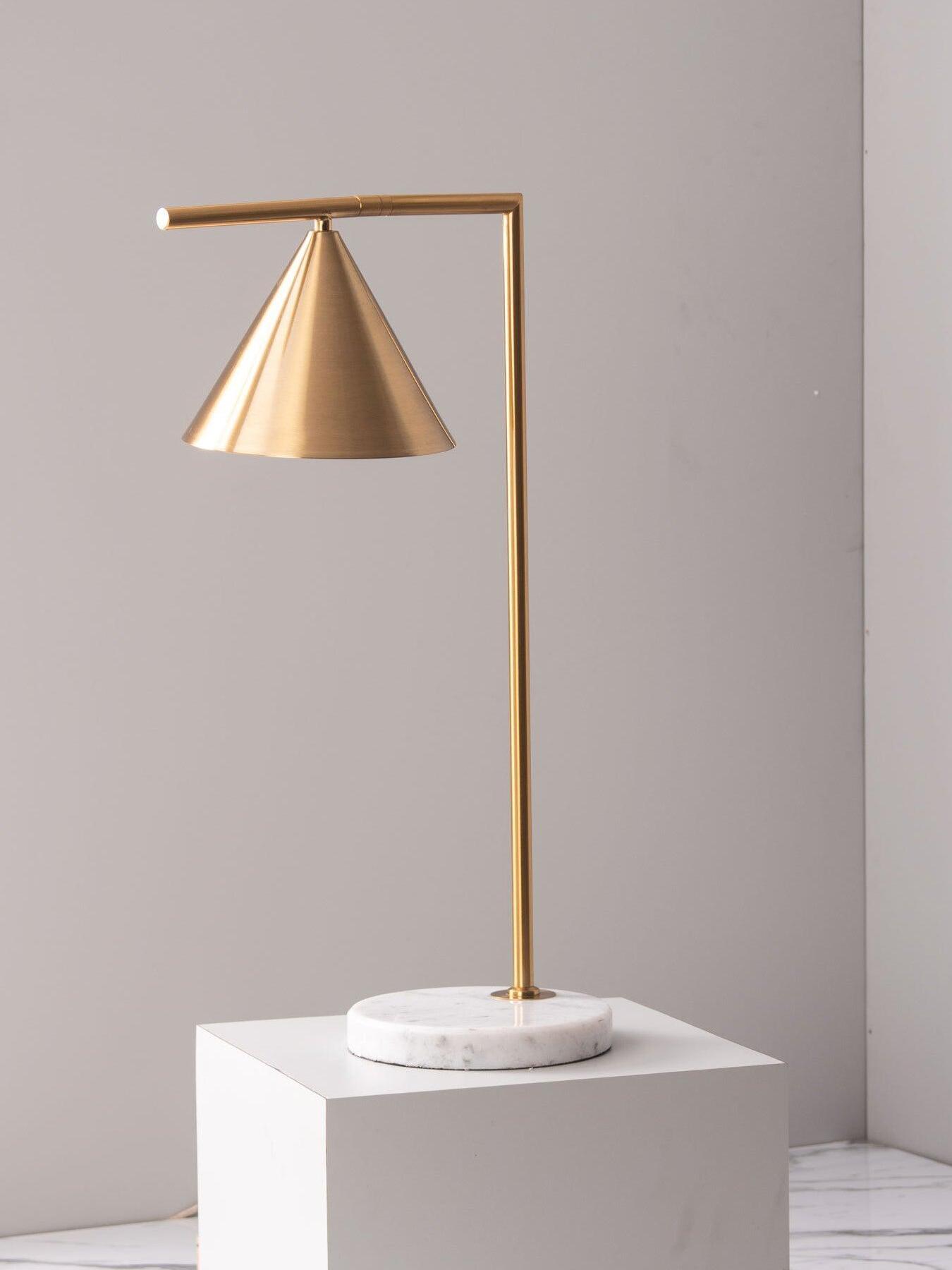 Gold-tone cone table lamp with marble disk base on white plinth