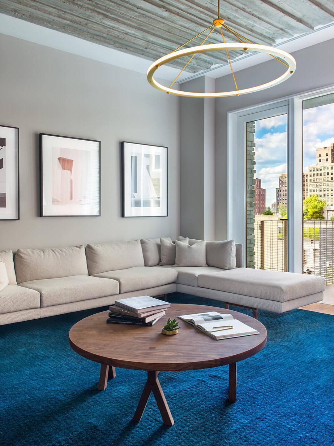 Gold ring pendant above blue-rug living room