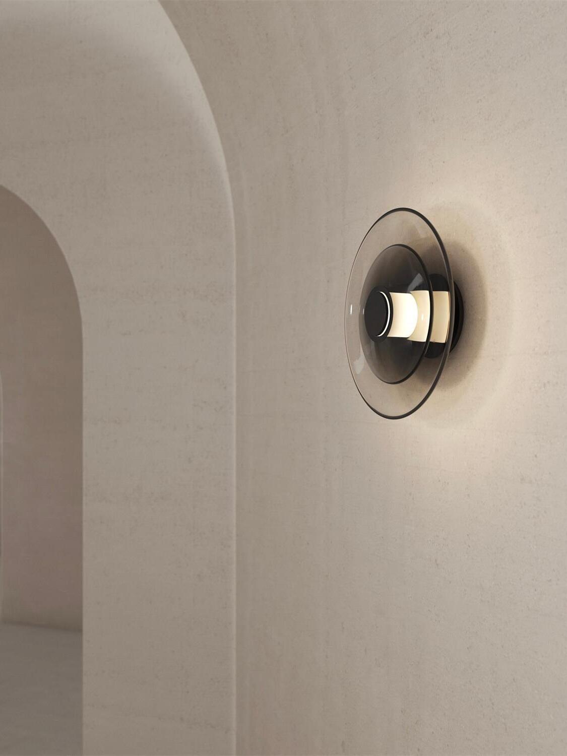 Black fitting and smoky curved glass disc on wall