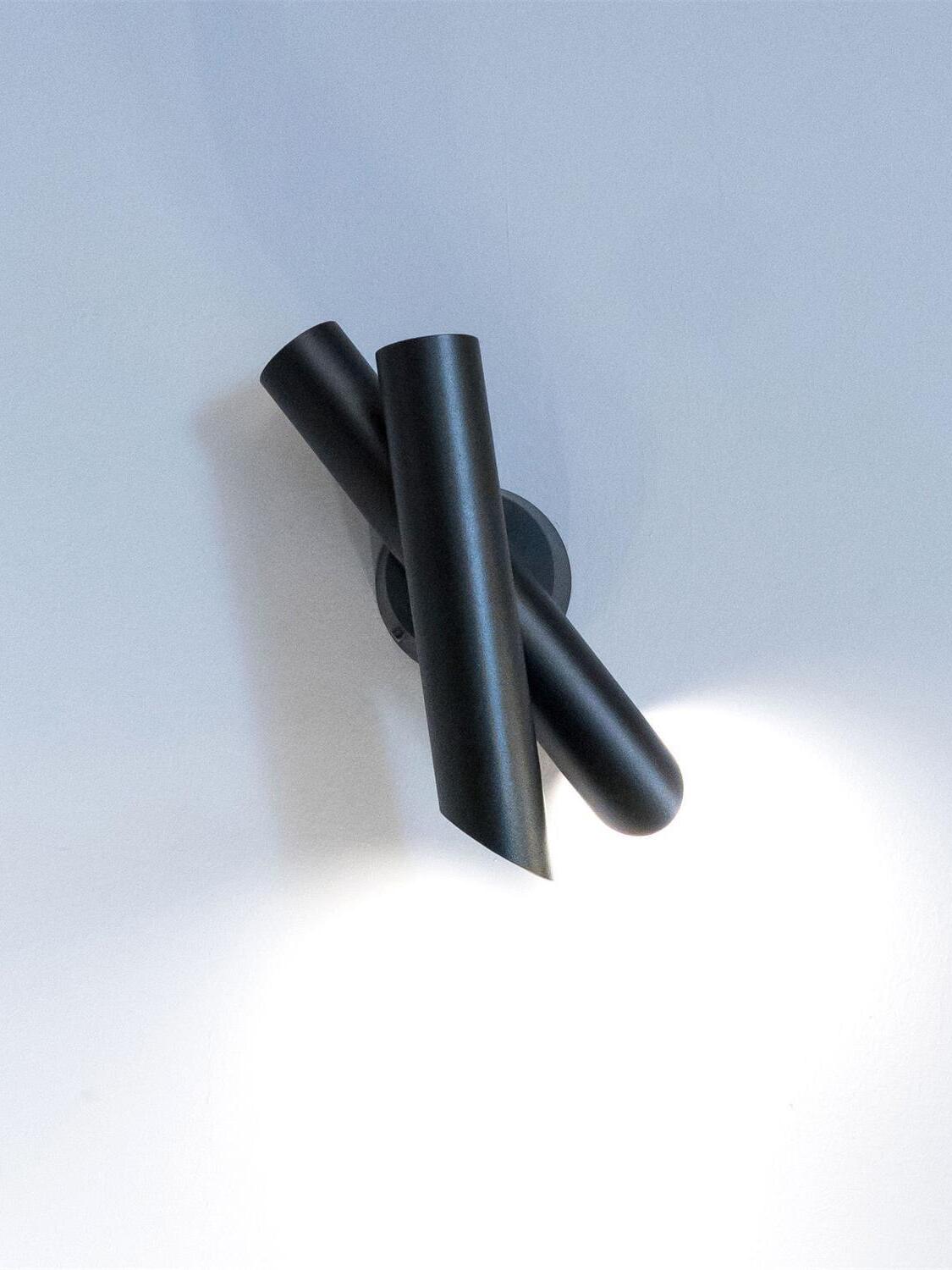 Black crossed-tube wall lamp viewed from above