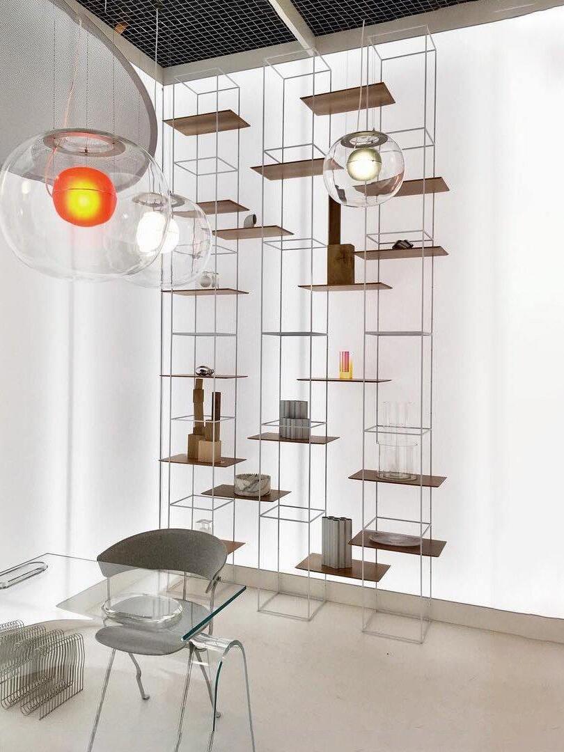 Red-centred glass pendant near a glass table and shelves