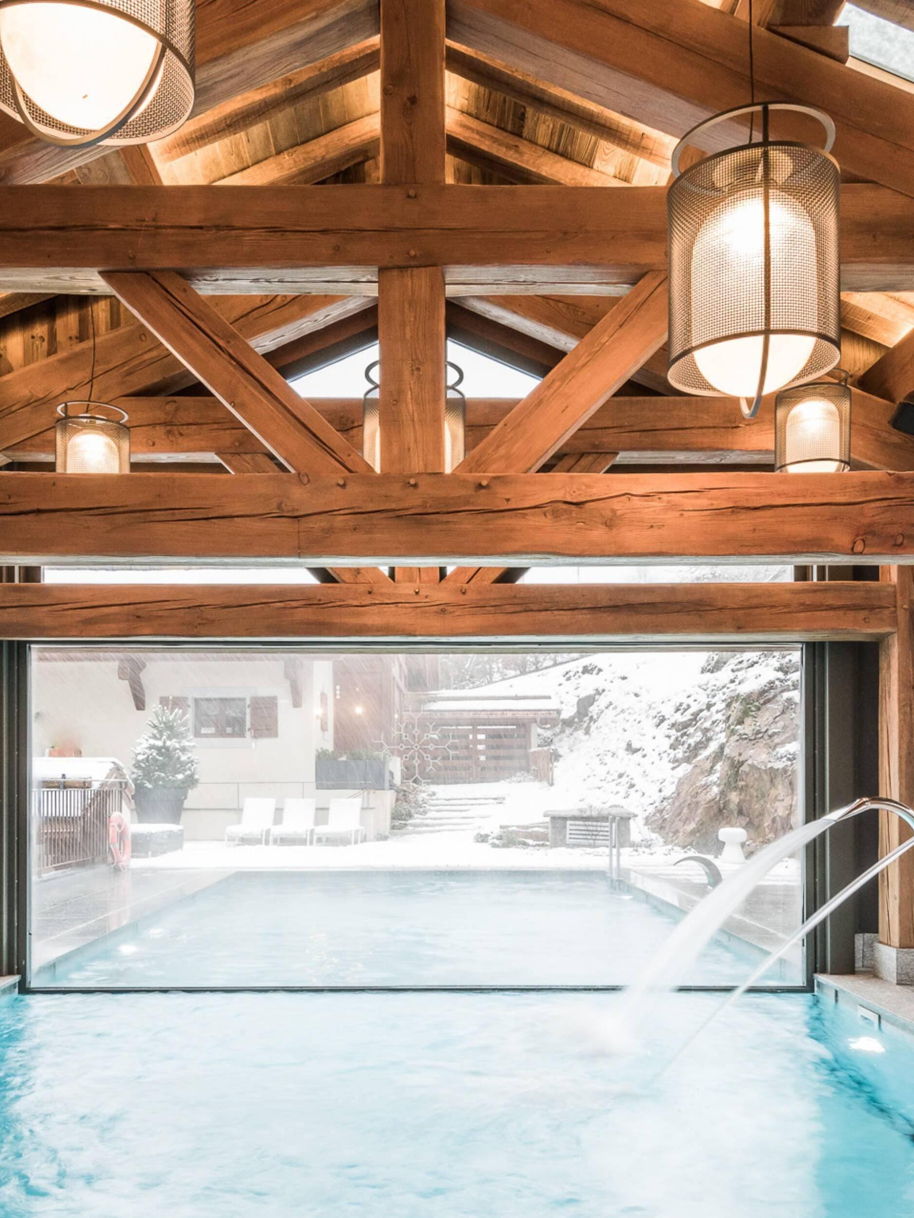 Two black hanging lanterns beside timber-framed pool