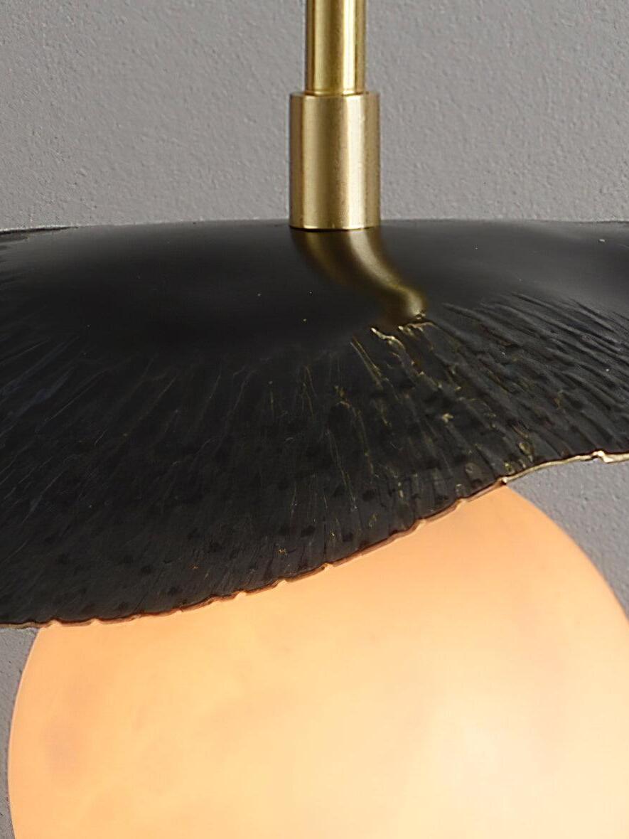 Close view of ridged black leaf surface and brass stem