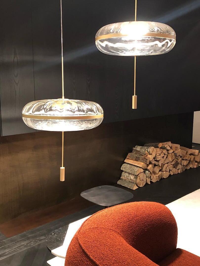 Two illuminated Jolie pendants near lounge seating