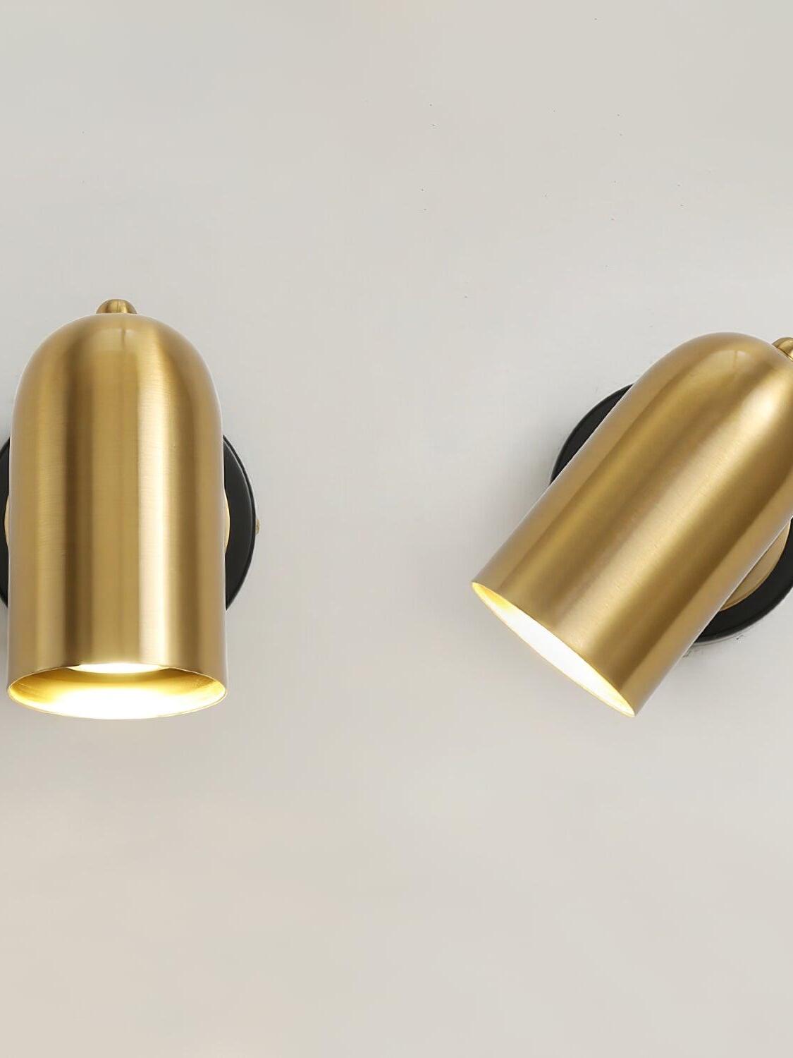 Two gold cylinder wall lamps shown upright and tilted