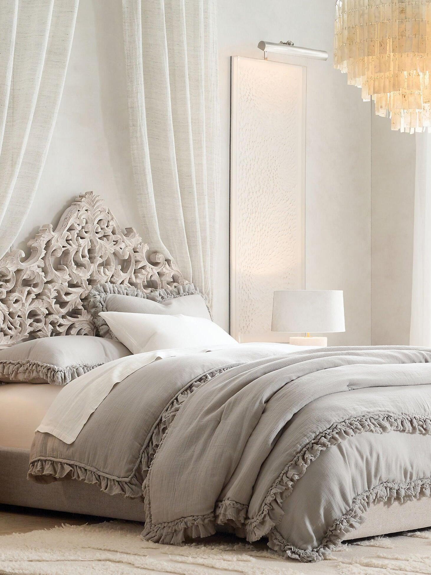 Bedroom with sheer curtains, a carved headboard and a shell pendant at the upper right