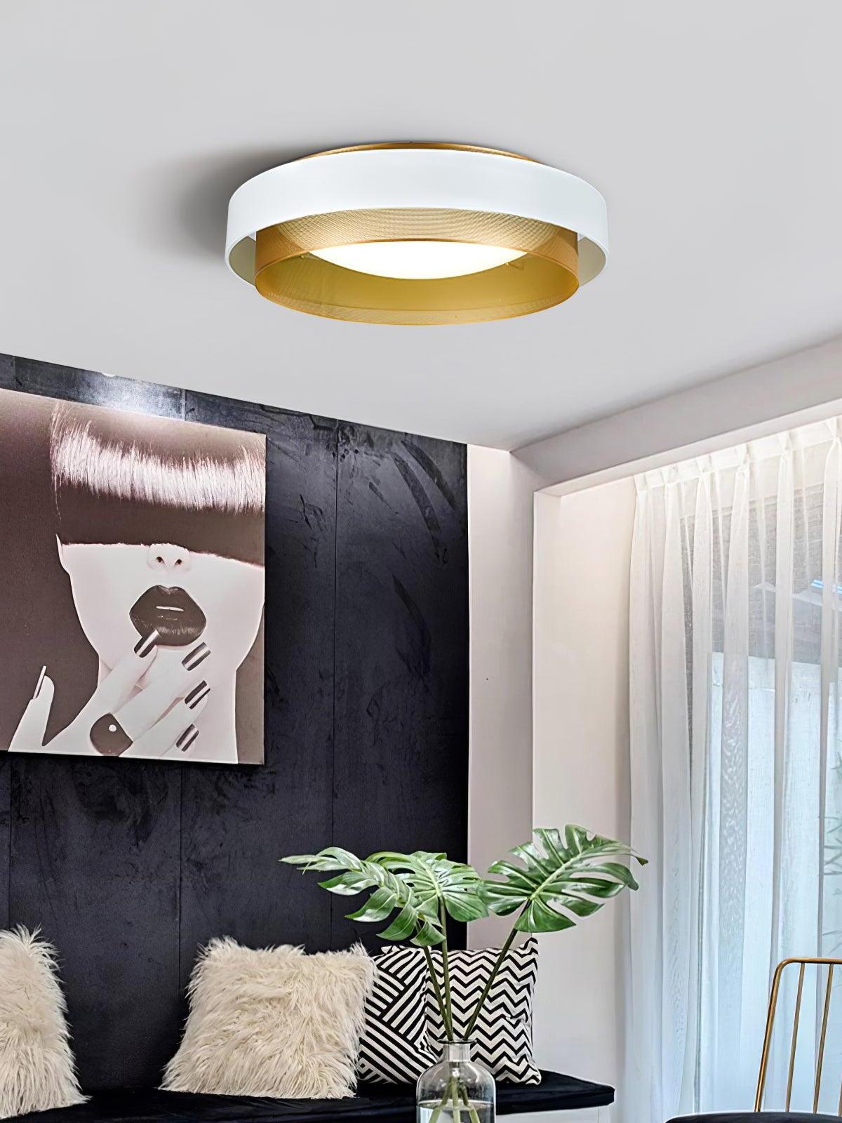 White and gold Nolan ceiling light above a seating area with cushions and a large plant