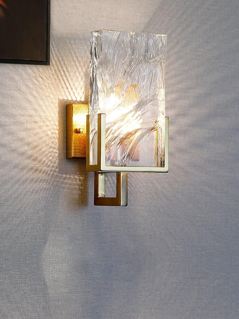 Lit Crystal wall light casting patterns on a grey wall