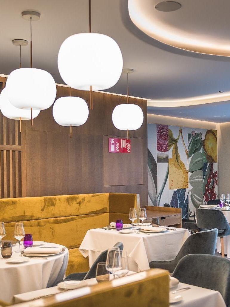 White glass pendant group above restaurant tables