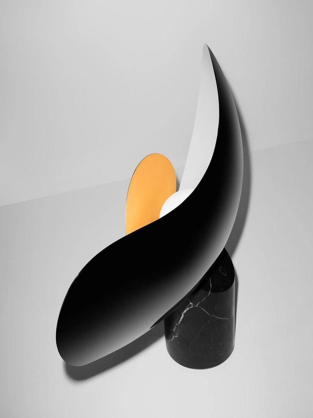 Black reverse of curved lamp shade above veined base