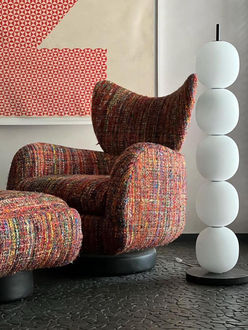 White globe lamp beside patterned wingback chair