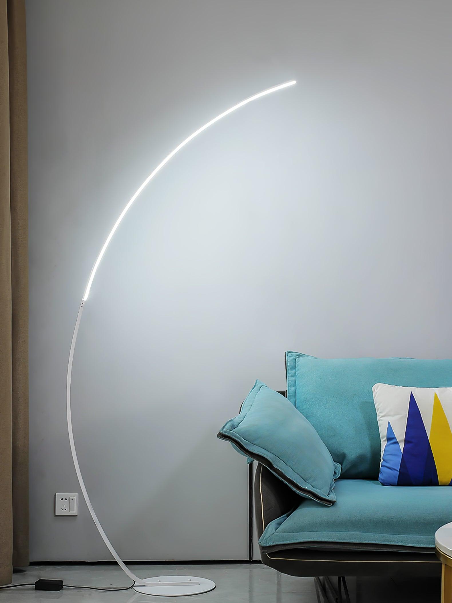 White arc floor lamp beside turquoise sofa