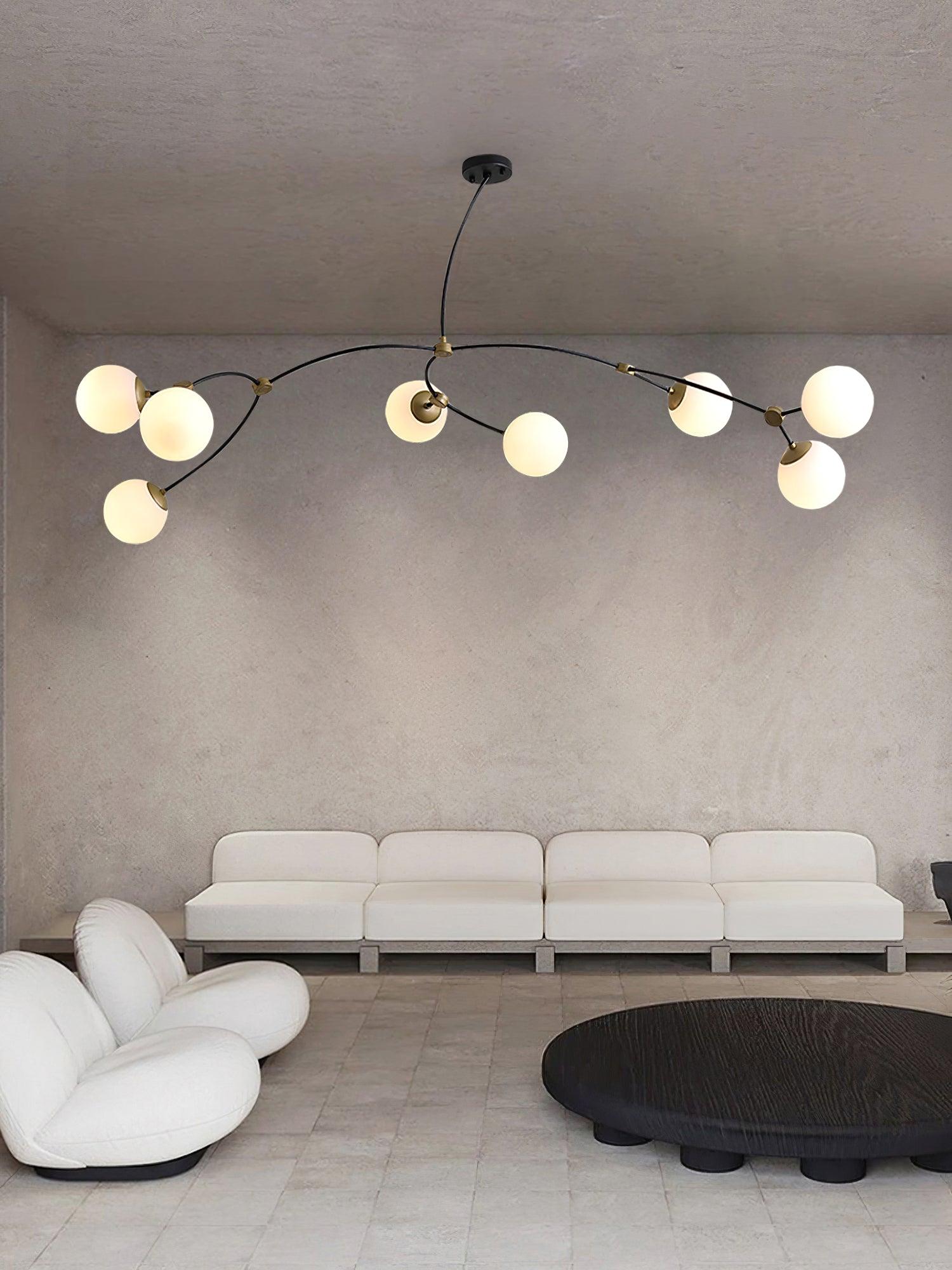 Eight-globe branching chandelier over a curved sofa