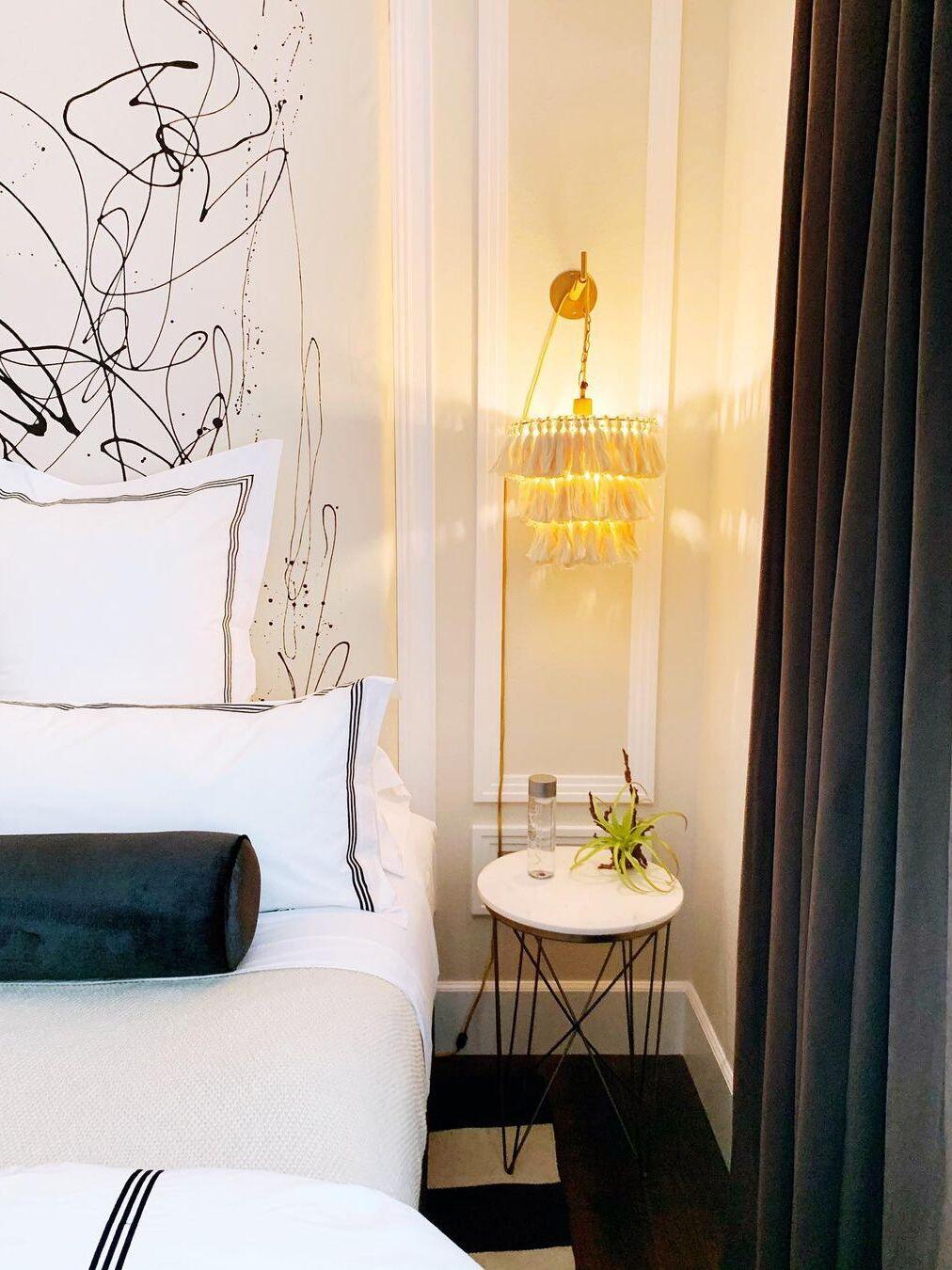 Tassel wall light above a small bedside table