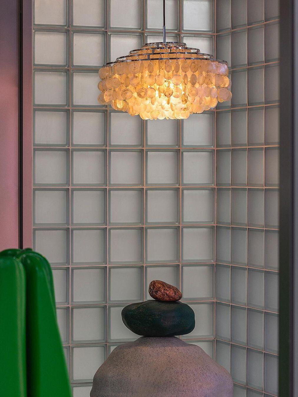 Warm shell pendant against a panelled wall