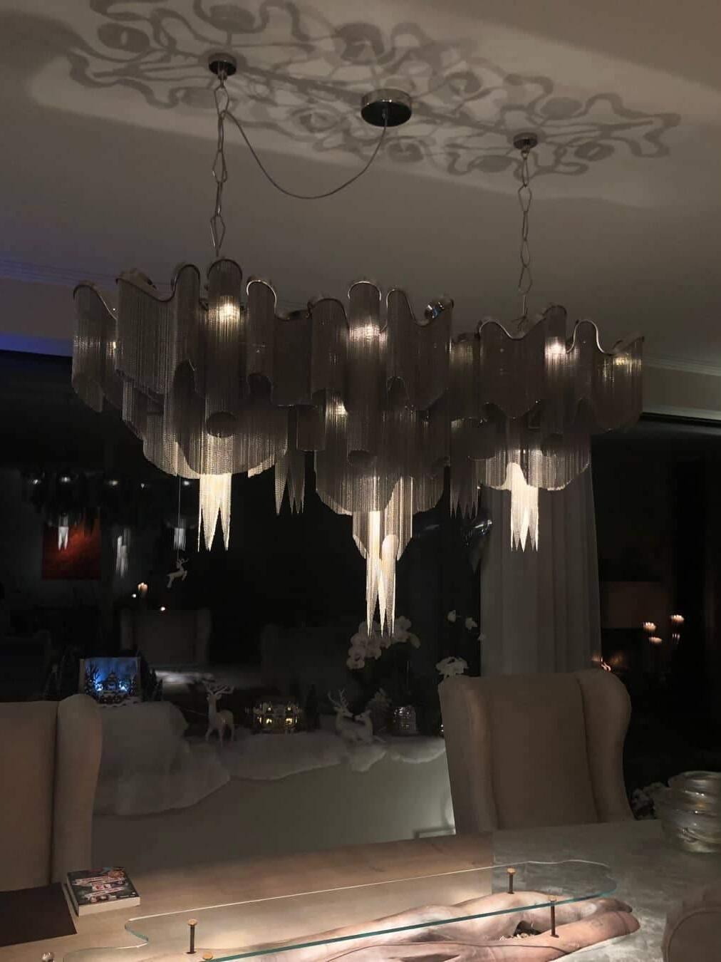 Long chain chandelier in a dim dining space