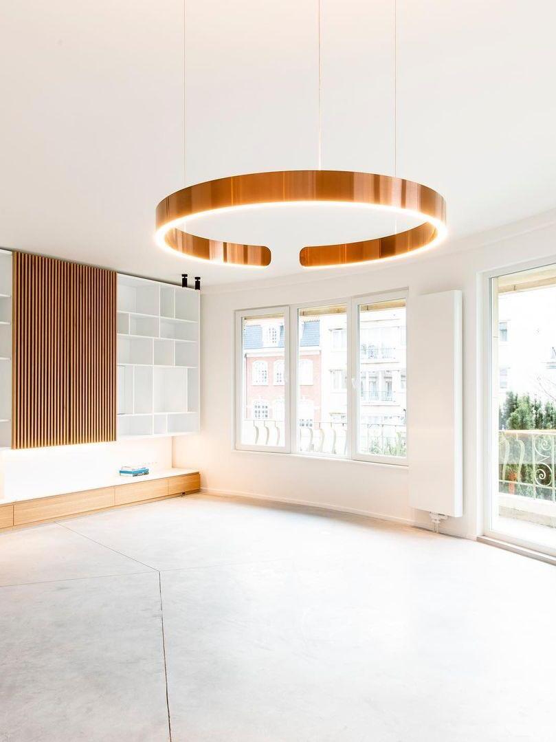 Gold-coloured open ring above a bright empty room
