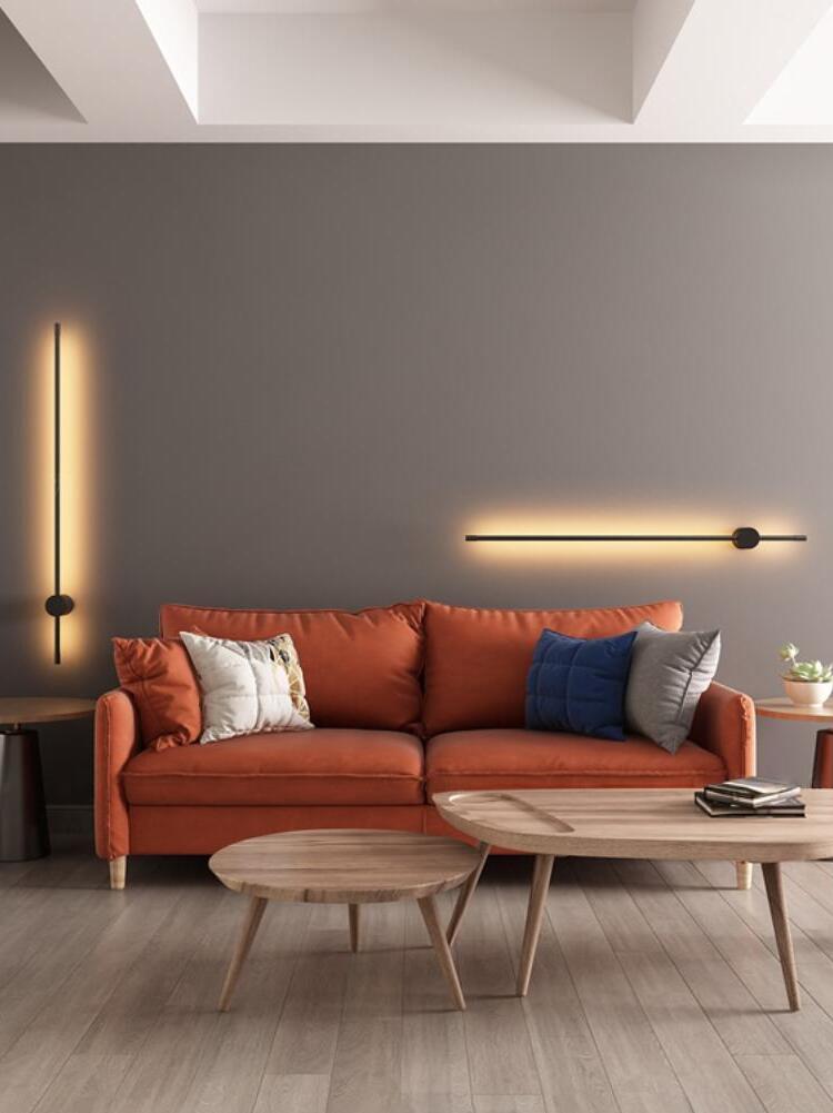 Vertical and horizontal linear lights beside an orange sofa