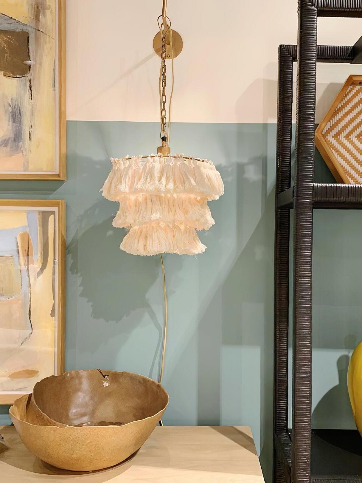 Illuminated cream tassels beside a mirror and bowl