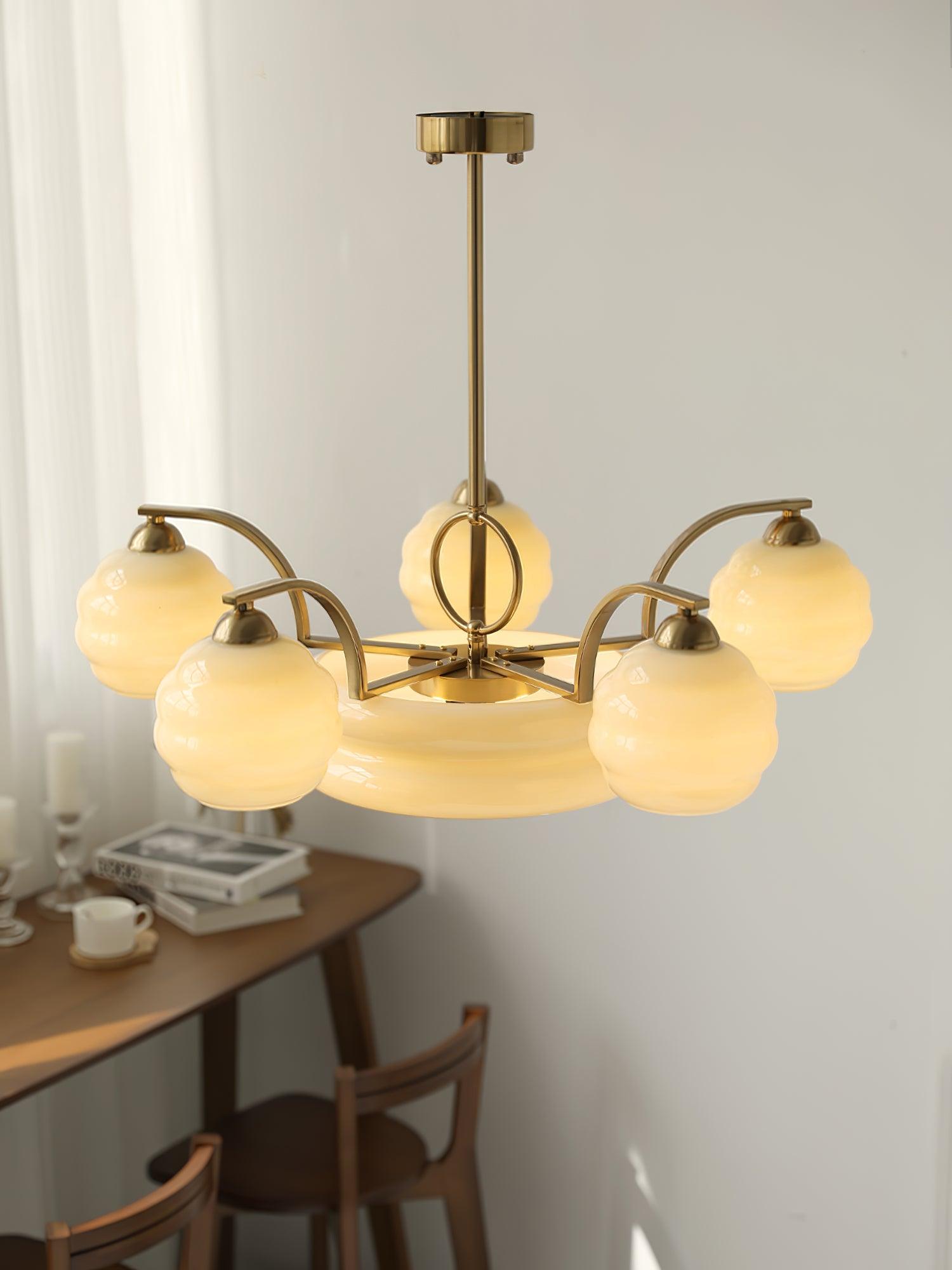 Gold-coloured curved arms surrounding central glass light
