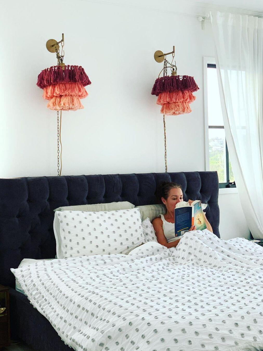Multicolour tassel pair above a dark upholstered bed