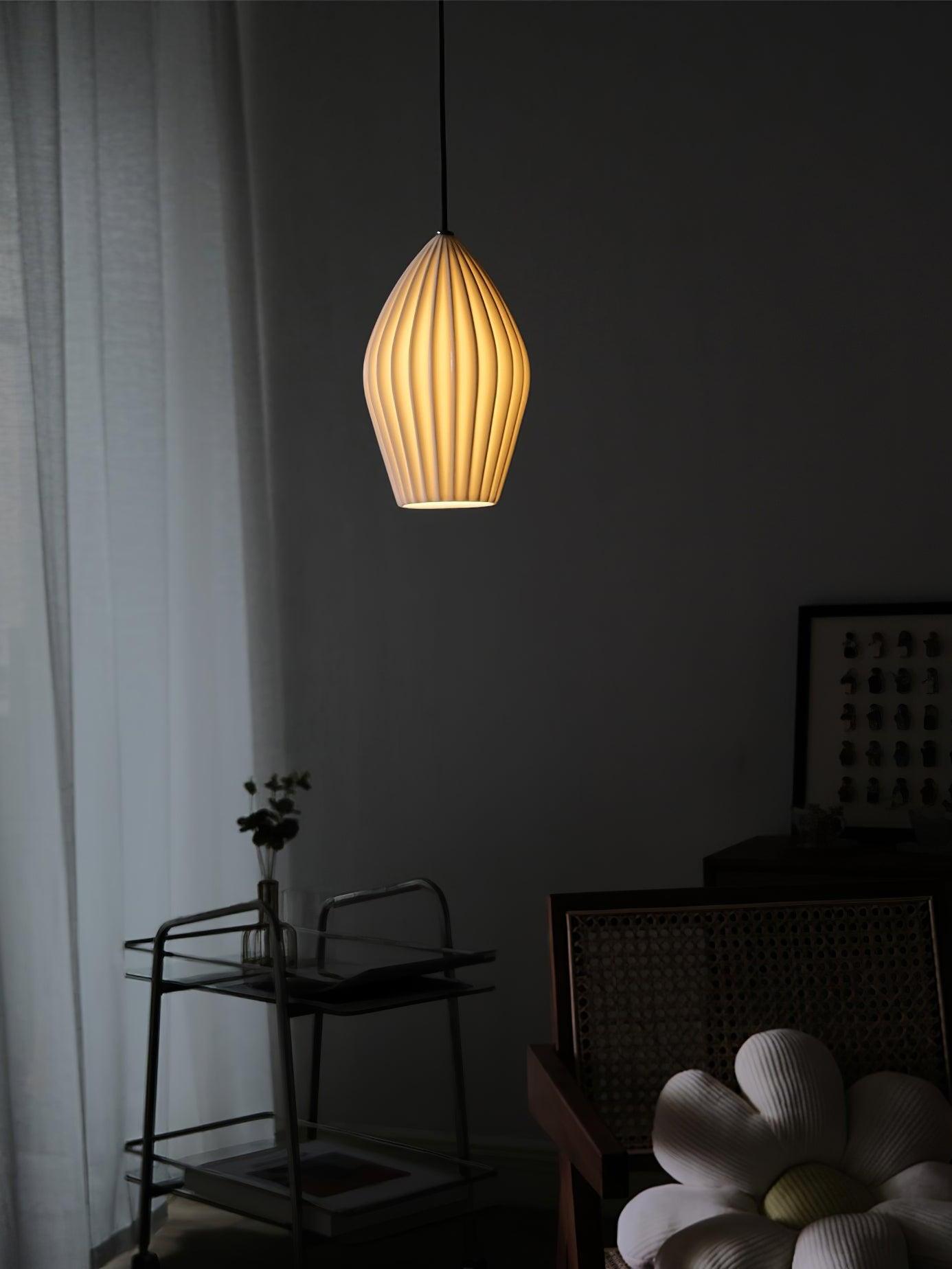 Single glowing white ribbed shade against a dark wall above a small table