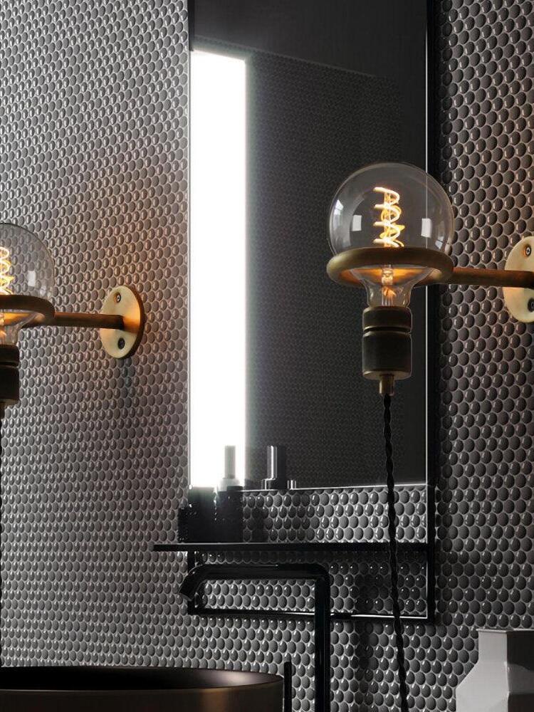 Upward-facing globe wall lights beside bathroom mirror