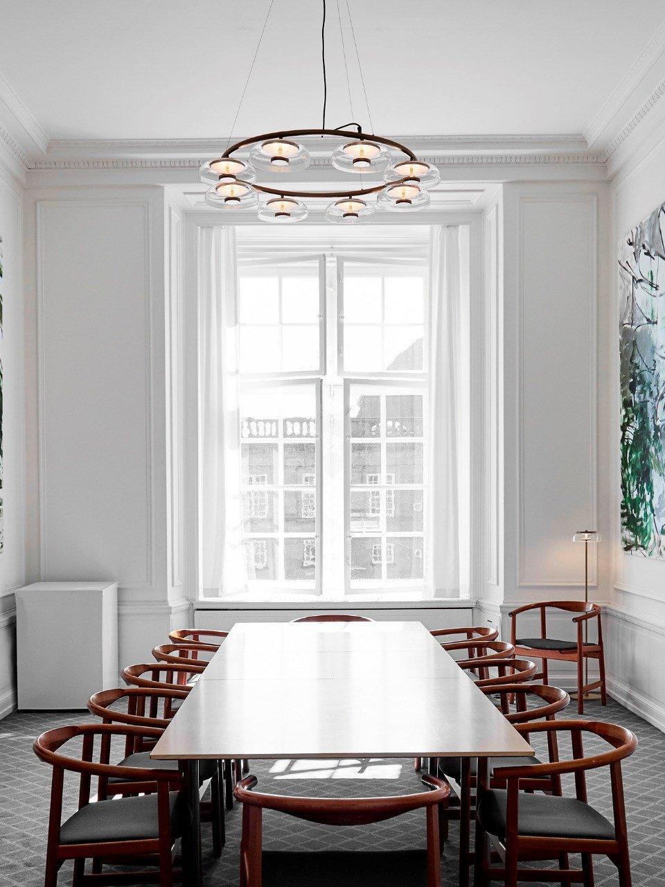 Blossi chandelier above a long dining table in a bright room
