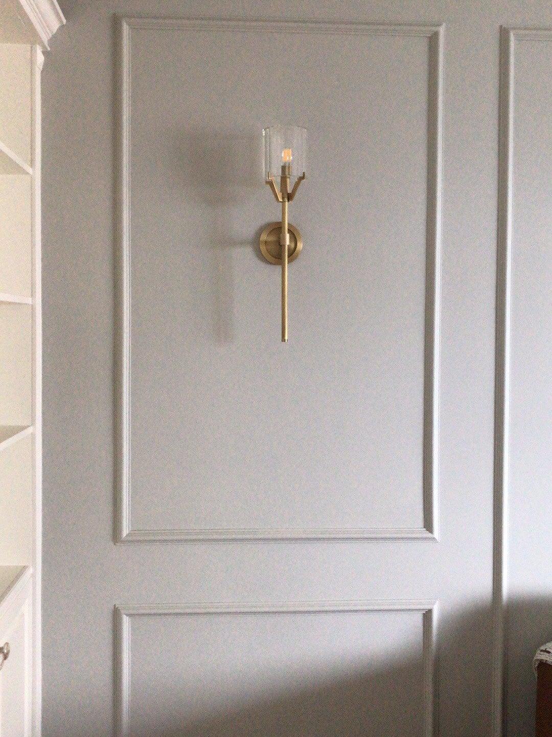 Small Gold sconce centred within wall panel moulding