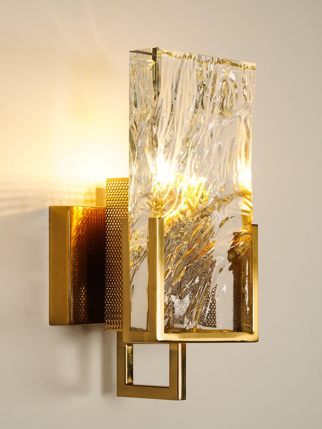 Front angle of Brass-finish wall light and clear textured slab
