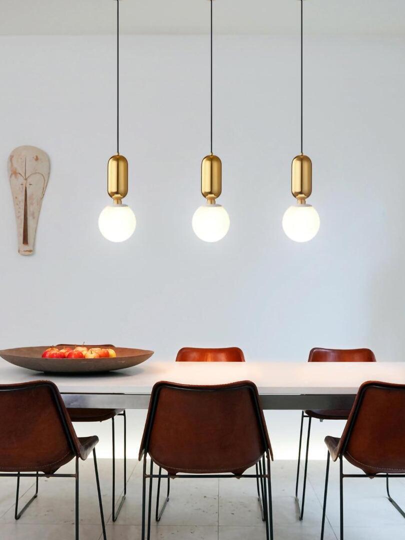 Three white globe pendants above a dining table